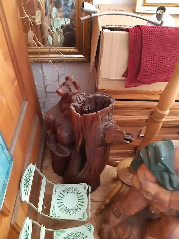 Bär stehend neben Holzstrunk als Schirmständer benutzbar