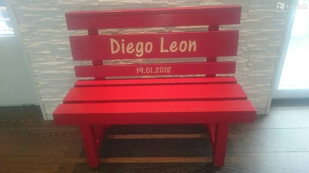 Feuerrote Kindersitzbank als Geburtsgeschenk