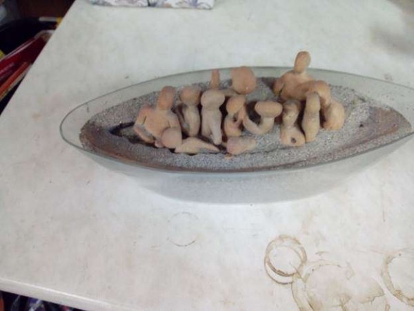 Ein aelteres Glasgefaess gefuellt mit Sand und Figuren