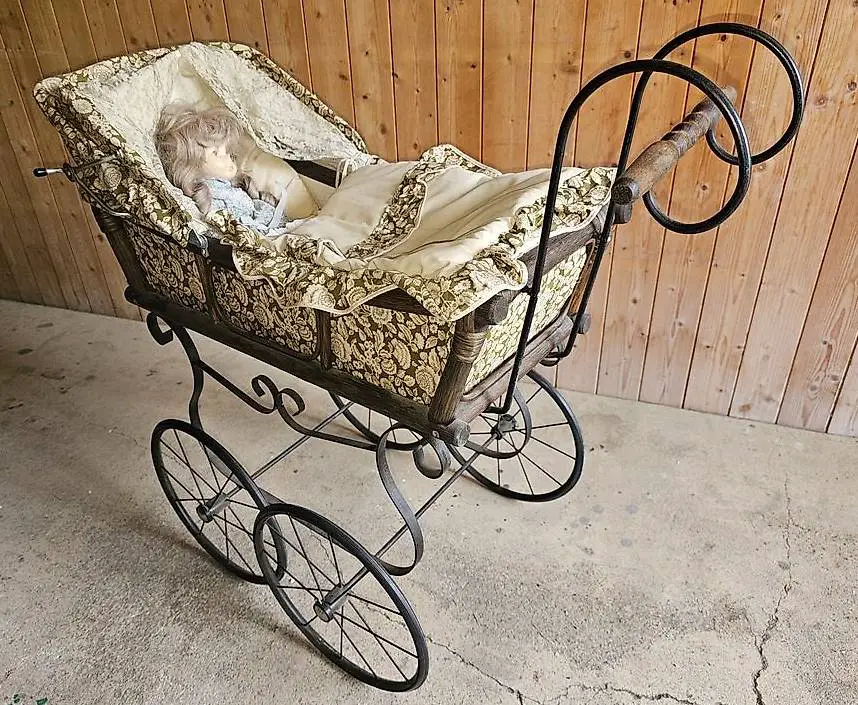 alter Kinderwagen mit Porzellanpuppe