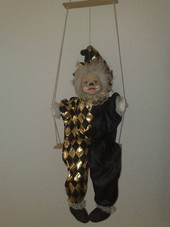 Clown / Harlekin auf Schaukel