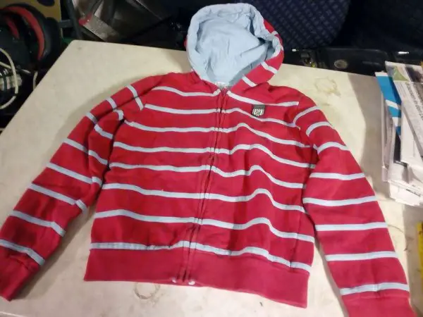 Ein älterer roter gestreifter Pullover für Jungs mit Kapuze