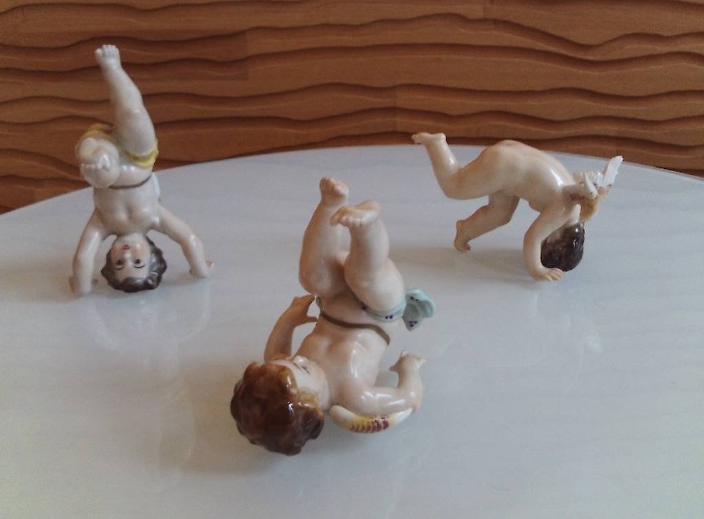 Drei spielende Porzellan-Engelskinder, antik um 1820