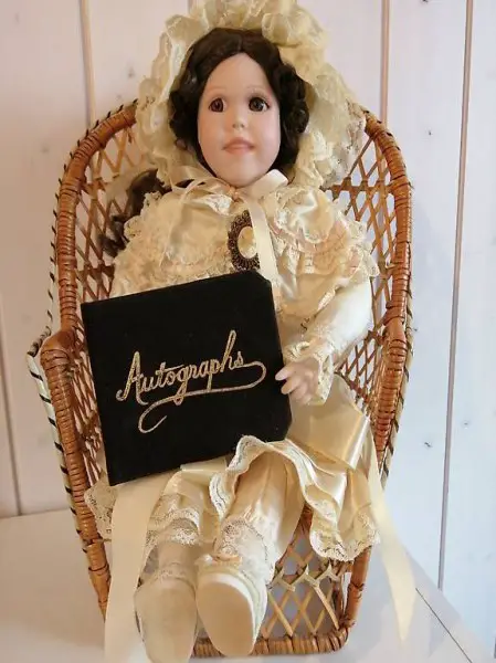 Porzellanpuppe mit Stuhl