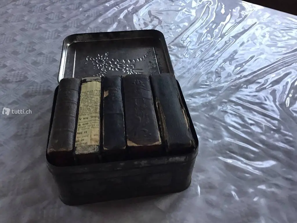 Alte Gebetsbücher mit Altersspuren in Blechbox