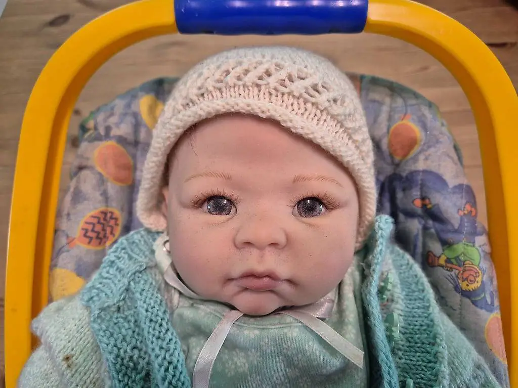 realistische Babypuppe im Maxicosi