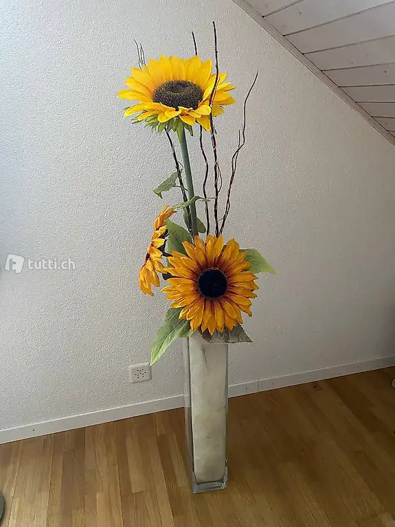 Glasvase mit künstlichen Sonnenblumen