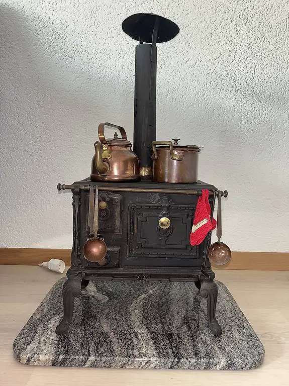 Kinderkochherd aus Gusseisen mit Kupfertöpfen
